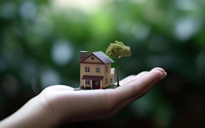 eine-hand-die-ein-kleines-haus-mit-einem-baum-auf-der-spitze-haelt eine-hand-die-ein-kleines-haus-mit-einem-baum-auf-der-spitze-haelt